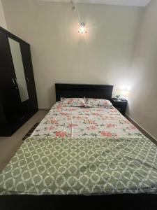 バンガロールにある1 BHK Flat with good amenities in Mysore Roadのベッドルーム1室(花柄のベッドカバー付きの大型ベッド1台付)
