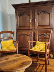 un meuble en bois avec deux chaises et une table en bois dans l'établissement L'envol, à Germond