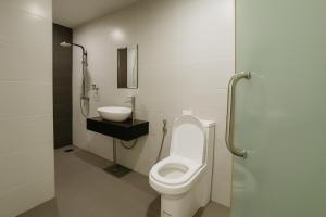 a bathroom with a toilet and a sink at Watermelon Hotel in Miri +20 photos