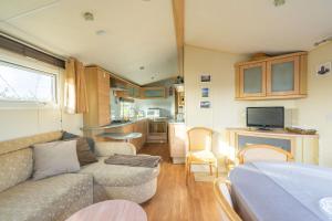 a caravan living room with a couch and a kitchen at Mobil Home 40 M², Proche De La Mer in Saint-Nazaire-sur-Charente