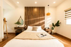 a bedroom with a bed and a mirror at The Morris Central Hotel - O'TEL in Da Lat