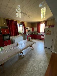 eine große Küche mit Tisch und Kühlschrank in der Unterkunft Гостевой дом с 7 комнатами in Schymkent