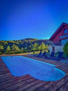 a swimming pool with chairs and a house at Family friendly house with a swimming pool Ogulin, Gorski kotar - 22843 in Ogulin