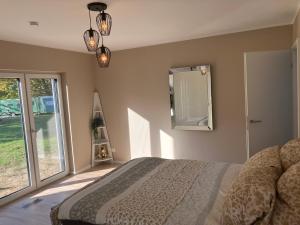 a bedroom with a bed and a large window at Ferienhaus Lake Escape in Lärz