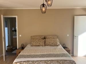 a bedroom with a bed with two pillows and two lights at Ferienhaus Lake Escape in Lärz +11 photos