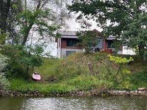 a house on top of a hill next to a river at Ferienhaus Lake Escape in Lärz
