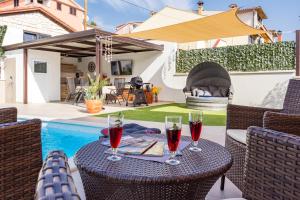 einen Tisch mit zwei Gläsern Wein auf einer Terrasse in der Unterkunft Family friendly house with a swimming pool Rovinj - 24669 in Rovinj