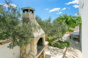 un horno al aire libre en un jardín con árboles en Apartments with parking space Seget Donji, Trogir - 23273, en Donji Seget
