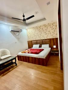 a bedroom with a large bed and a chair at Moti Mahal Delux in Bahādurgarh