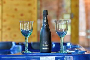 eine Flasche Wein und zwei Gläser auf einem Tisch in der Unterkunft Family friendly house with a swimming pool Benkovec, Zagorje - 24902 in Bednja