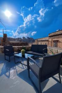 a patio with two chairs and a table on a roof at Carmelita Valletta in Valletta