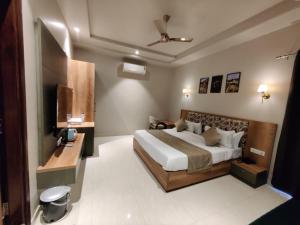 a bedroom with a large bed and a television at Infinity Hotel & Resort, Chikani , Alwar in Alwar +92 photos