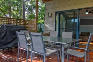 a patio with a table and chairs on a deck at Lockhart Leafy Cottage - walk to Mollymook Beach in Mollymook