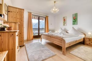a bedroom with a bed and a large window at Panorama Ferienwohnung Tschengla in Bürserberg