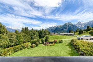 a car parked in a field with mountains in the background at Panorama Ferienwohnung Tschengla in Bürserberg