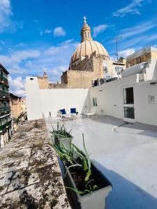 a balcony with chairs and plants on a building at Carmelita Valletta in Valletta +54 photos