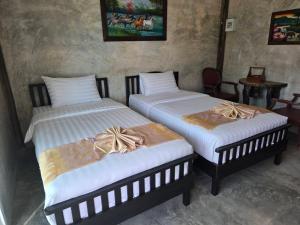 deux lits côte à côte dans une pièce dans l'établissement ขวัญใจปราณ รีสอร์ท, à Ban Pak Nam Pran