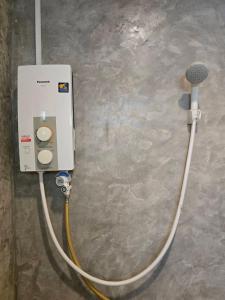 un chauffe-eau est fixé à un mur dans l'établissement ขวัญใจปราณ รีสอร์ท, à Ban Pak Nam Pran
