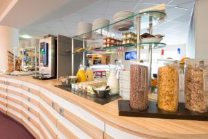 a buffet line with food on it in a restaurant at Hôtel Confort La Rochelle Centre les Minimes in La Rochelle