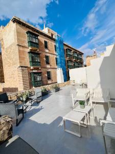 a patio with chairs and tables in front of a building at Carmelita Valletta in Valletta