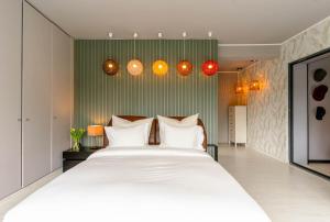 ein großes weißes Bett in einem Zimmer mit Lichtern in der Unterkunft Herdade de Aroeira Golf & Beach in Almada + 60 Fotos