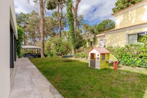 ein Garten mit einem Spielhaus und einem Spielzeug in der Unterkunft Herdade de Aroeira Golf & Beach in Almada