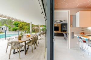 eine offene Küche und ein Esszimmer mit Tisch und Stühlen in der Unterkunft Herdade de Aroeira Golf & Beach in Almada