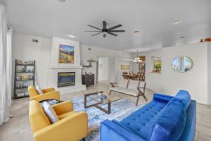 un salon avec un canapé bleu et des chaises dans l'établissement Rooftop Hot Tub Epic Red Rock Views, à Sedona