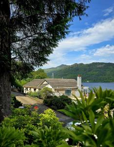 a house with a view of a lake at Jenny's Bay with Hot Tub in Lochgoilhead