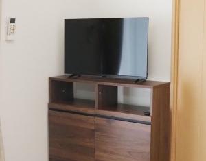 a flat screen tv sitting on top of a wooden entertainment center at Maison West Building B - Vacation STAY 18462 in Shimo-nogami