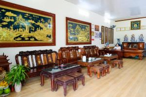a room with chairs and tables and paintings on the wall at Phúc Lộc Hotel Ninh Bình in Ninh Binh