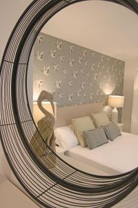 a mirror reflecting a bedroom with a bed with birds on it at Exotik City Apartments 5 in Dos Hermanas