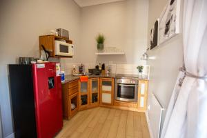 a kitchen with a red refrigerator and wooden cabinets at A Touch of Bushveld by the Sea in Langebaan +15 photos