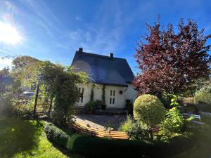 Ein weißes Haus mit der Sonne am Himmel in der Unterkunft Romantische Ferienwohnung für 5 mit Hund im Erzgebirge in Beierfeld