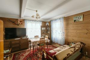 a living room with a couch and a tv and a table at Dom na wsi u Kasi HAJNÓWKA BIAŁOWIEŻA NA WYŁĄCZNOŚĆ in Stare Berezowo