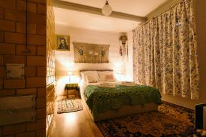 a bedroom with a bed with a green blanket at Dom na wsi u Kasi HAJNÓWKA BIAŁOWIEŻA NA WYŁĄCZNOŚĆ in Stare Berezowo