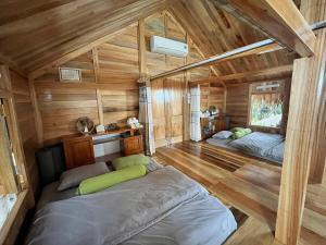 Zimmer mit 2 Betten in einer Hütte mit Holzwänden in der Unterkunft Na Tuệ An-Homestay 81 Võ Văn Kiệt in Tuyên Quang