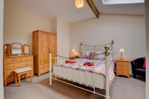 Un dormitorio con una cama y una cómoda. en Brynheulwen, en Llanilar