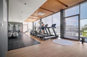 a gym with a woman exercising on treadmills at 1412 Wyndham Gardens Elegant Pool Condo in Nai Thon Beach