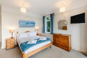 a bedroom with a bed and a flat screen tv at Francis Cottage in Woolacombe