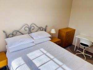 een slaapkamer met een bed met een bureau en een bed sidx sidx sidx bij Hillside Retreat with Pool in Flagstaff Hill