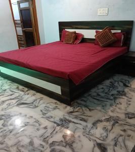 a bed with red sheets and pillows on top of the floor at Lakshman Guest House Ayodhya in Jāmb