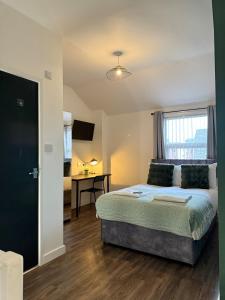 a bedroom with a bed and a desk and a window at Modern & Spacious, 4BR 4Bath, Parking, Sleeps 8 in Coventry