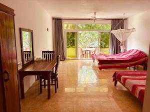 a living room with a wooden table and a desk at Raja Beach Hotel in Balapitiya +236 photos