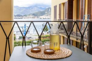 een tafel met een fles en twee glazen op een balkon bij IseoLakeRental - Delfina in Pisogne