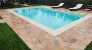 einen Pool mit Steinboden und blauem Wasser in der Unterkunft Villa Privata Lux con piscina San Teodoro in Porto Ottiolu