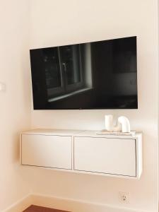 een witte kast met een tv aan de muur bij Eulennest mit Whirlpool und Sauna in Bermel +23 foto's