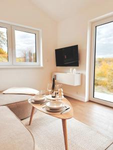 een woonkamer met een tafel en 2 ramen bij Eulennest mit Whirlpool und Sauna in Bermel