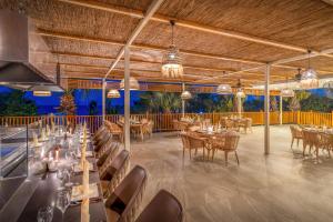a dining room with tables and chairs and chandeliers at Delphin Palace Hotel in Lara