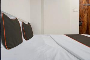 PhūrsungiにあるCollection O Aachal Hotel & Lodgingの黒とオレンジの縞模様の白いベッド